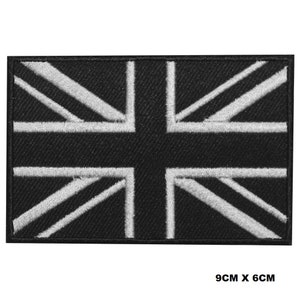 May include: Black embroidered iron-on patch of the Union Jack flag with white stitching. The patch measures 9 inches by 6 inches.