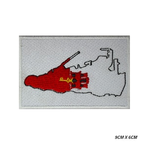 May include: White embroidered patch with a red outline of the island of Bermuda. The island is filled with the red and white flag of Bermuda, which features a red lion and a golden key.