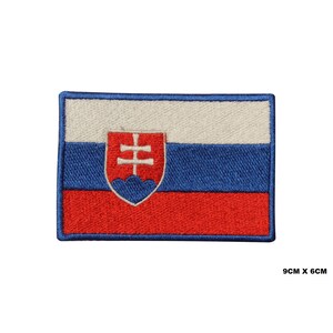 Pode incluir: Etiqueta bordada da bandeira eslovaca. A bandeira é branca, azul e vermelha com o brasão de armas eslovaco no centro. A etiqueta mede 9 cm por 6 cm.