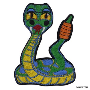 Peut inclure: Patch brodé représentant un serpent vert, jaune et bleu avec une langue rouge et une queue orange. Le serpent est enroulé en position défensive, la tête levée. Le patch mesure 5 cm sur 7 cm.