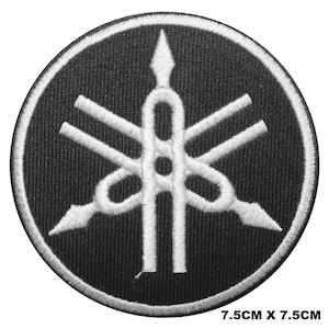 Op de afbeelding: Zwarte en witte geborduurde patch met het Yamaha-stemvorklogo. Het logo is een gestileerde stemvork met drie tanden. De patch is 7,5 cm bij 7,5 cm.
