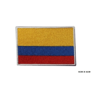 May include: An embroidered patch of the Colombian flag. The flag is yellow, blue, and red. The patch is 9 cm by 6 cm.