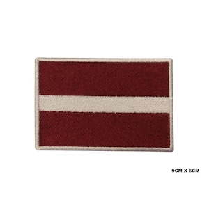 May include: Embroidered patch of the Latvian flag. The flag is red with a white horizontal stripe in the center. The patch is 9 cm by 6 cm.