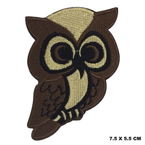 May include: Brown and beige embroidered owl patch. The owl has large, round eyes and a detailed design. The patch is 7.5 inches by 5.5 inches.