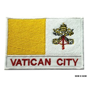 Könnte beinhalten: Gestickter Aufnäher mit der Flagge des Vatikans. Die Flagge ist gelb und weiß mit dem päpstlichen Wappen in der Mitte. Der Aufnäher ist 9 cm x 6 cm groß und trägt die Aufschrift "Vatican City" in rot auf weißem Hintergrund.