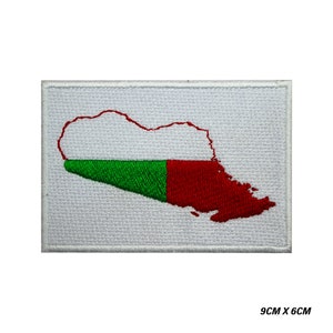 Puede incluir: Parche bordado con el contorno de un país en rojo y verde, sobre fondo blanco. El parche mide 9 cm por 6 cm.