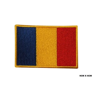 May include: An embroidered patch of the Romanian flag. The flag is blue, yellow, and red with a gold border. The patch is 9 cm by 6 cm.