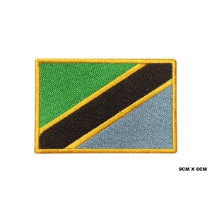 May include: An embroidered patch featuring the flag of Tanzania. The flag is green, black, yellow, and blue with a diagonal stripe pattern. The patch is 9 cm by 6 cm.