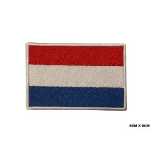 Puede incluir: Un parche bordado de la bandera holandesa, con los colores rojo, blanco y azul. El parche mide 9 cm por 6 cm.