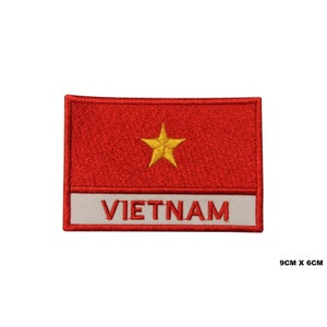 Puede incluir: Parche rojo bordado con una estrella amarilla y la palabra "VIETNAM" en letras blancas. El parche mide 9 cm por 6 cm.