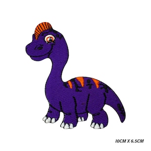 Könnte beinhalten: Lilafarbener gestickter Bügelaufkleber mit einem Cartoon-Dinosaurier mit orangefarbenen Akzenten. Der Dinosaurier steht auf allen Vieren und hat einen freundlichen Ausdruck. Der Patch misst 10 cm x 6,5 cm.