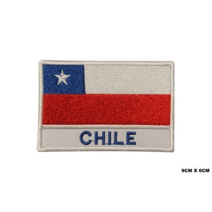May include: Embroidered patch featuring the Chilean flag with a white star on a blue field, a red horizontal stripe, and a white horizontal stripe. The patch has a white border and the word "CHILE" in white lettering on a gray background. The patch measures 9 cm by 6 cm.