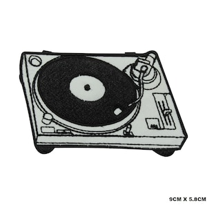 Puede incluir: Parche de hierro bordado en blanco y negro de un tocadiscos de estilo vintage con un disco en el plato. El parche mide 9 cm por 5,8 cm.