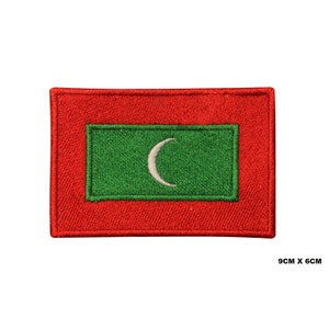 May include: A red embroidered patch with a green rectangle in the center. The green rectangle has a white crescent moon in the center. The patch measures 9 cm by 6 cm.