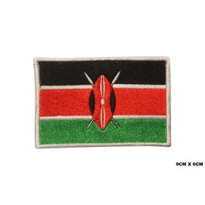May include: Embroidered patch of the Kenyan flag. The flag is black, red, and green with a white shield and two crossed spears in the centre. The patch is 9 cm by 6 cm.