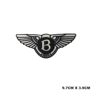 Puede incluir: Parche bordado en blanco y negro con un emblema alado y una letra "B" blanca en el centro. El parche mide 9,7 cm por 3,9 cm.