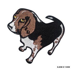 Puede incluir: Parche bordado para planchar de un perro beagle marrón y negro con marcas blancas. El perro está de pie sobre sus cuatro patas con la cabeza inclinada hacia un lado. El parche mide 8,2 cm por 7,5 cm.