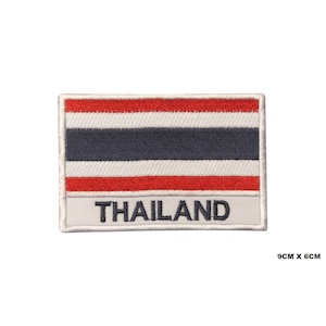 Puede incluir: Un parche bordado con la bandera de Tailandia. El parche es blanco con rayas rojas, blancas y azules. La palabra "TAILANDIA" está bordada en blanco debajo de la bandera. El parche mide 9 cm por 6 cm.
