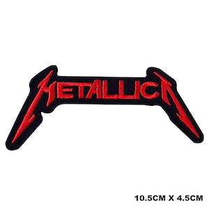 May include: Red embroidered Metallica logo patch on a black background. The logo is a stylized "M" with the word "Metallica" written across it. The patch is 10.5 cm by 4.5 cm.