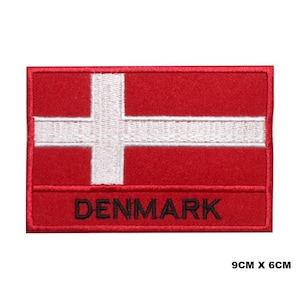 May include: Red and white embroidered patch with the word "DENMARK" in black lettering. The patch is 9 inches by 6 inches.