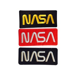 May include: Three embroidered patches with the NASA logo. The top patch is black with yellow lettering. The middle patch is red with white lettering. The bottom patch is black with white lettering.