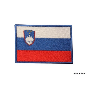 May include: Embroidered patch of the Slovenian flag. The flag is white, blue, and red with the Slovenian coat of arms in the top left corner. The patch is 9 cm by 6 cm.