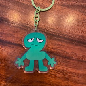 May include: A white ceramic mug with a black handle and the text "But First, Coffee" in a bold, black font. The mug is sitting on a wooden surface. The mug is 4 inches tall.