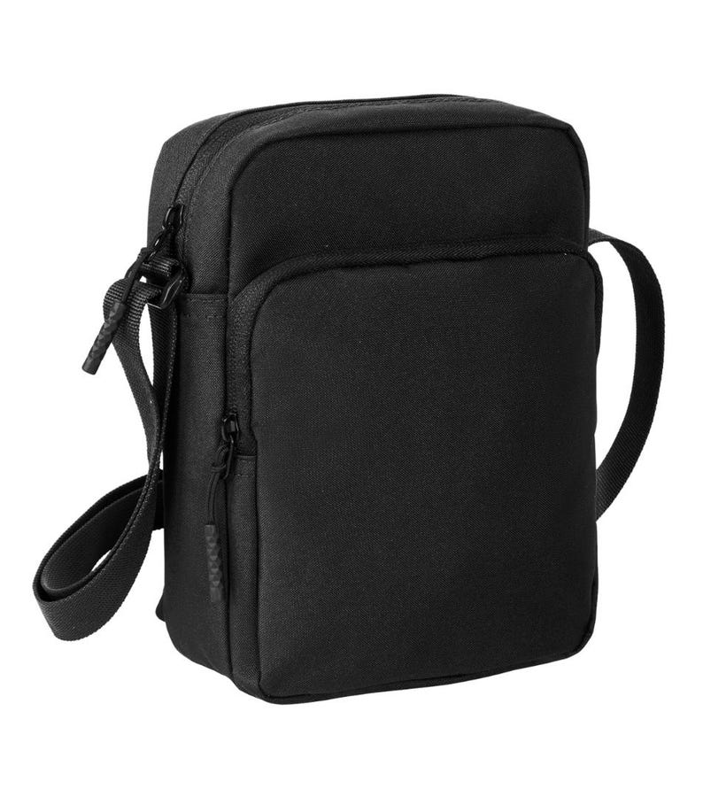Pu&ograve; includere: Una borsa a tracolla nera rettangolare con uno scomparto principale con cerniera e una tasca frontale pi&ugrave; piccola. La borsa ha una tracolla lunga e regolabile e una maniglia superiore. Realizzata in materiale opaco resistente.