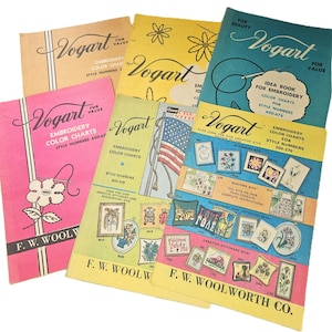 May include: A collection of vintage Vogart embroidery color chart booklets. The booklets feature colorful covers with floral and patriotic designs, and text such as "Embroidery Color Charts" and "Idea Book for Embroidery". The booklets are from F.W. Woolworth Co.
