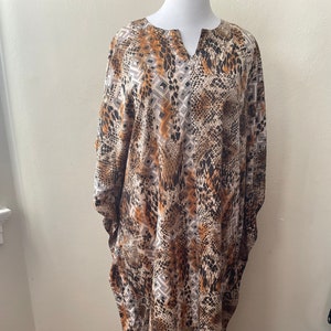 May include: A long, flowing, brown and white patterned dress with a V-neckline.