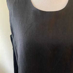 May include: A sleeveless black linen dress with a scoop neck.