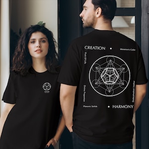 May include: Two black t-shirts with a white geometric design on the back. The design includes a circle with a star inside, surrounded by smaller circles. The text "CREATION", "Fruit Of Life", "Divine Proportion", "Platonic Solids", "Metatron's Cube", "Dodecahedron | Aether", and "HARMONY" are printed on the shirt.