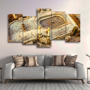 May include: An aerial view of the Kaaba in Mecca, Saudi Arabia. The Kaaba is a cube-shaped building that is the holiest site in Islam. It is surrounded by a large crowd of people performing the Hajj pilgrimage.