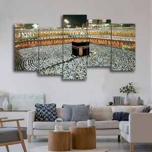 May include: A multi-panel canvas print depicting a large crowd of people gathered around the Kaaba in Mecca, Saudi Arabia. The Kaaba is a cube-shaped building that is considered the holiest site in Islam.