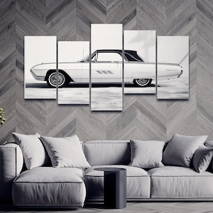 May include: Black and white five-panel canvas art print of a classic convertible car. The car is white with a black convertible top and whitewall tyres. The artwork is displayed above a grey sofa and a small black side table.