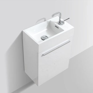 Puede incluir: Mueble de ba&ntilde;o blanco de pared con un lavabo simple y un grifo cromado. El mueble tiene un solo caj&oacute;n con una manija cromada.