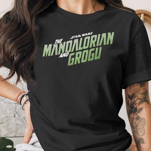 Black t-shirt with The Mandalorian and Grogu logo.