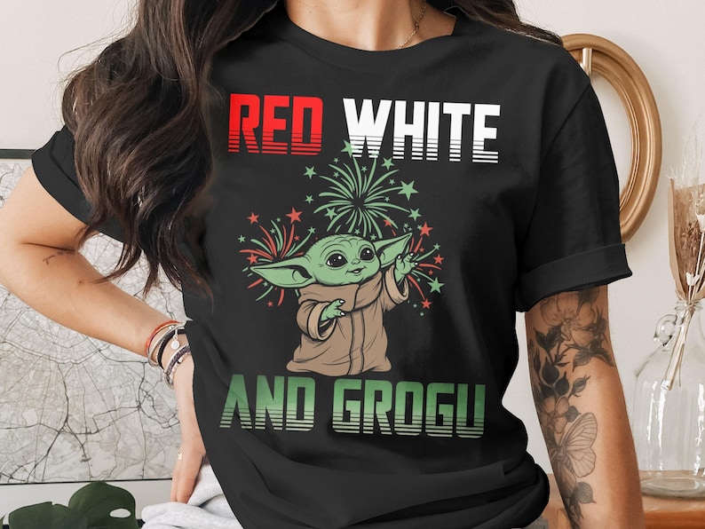Grogu in a red, white, and patriotic t-shirt with fireworks.