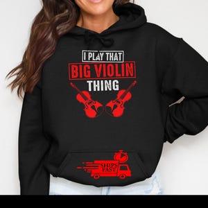 May include: Black hoodie with the text "I PLAY THAT BIG VIOLIN THING" in white and red. Two red violins are below the text. A red graphic of a truck with the words "SHIPS FAST" is at the bottom.