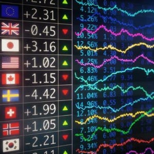 May include: A digital display showing currency exchange rates and fluctuating stock market data. The left side lists currencies like EUR, GBP, JPY, and USD with their corresponding flags and values. The right side displays colorful, dynamic line graphs representing market trends.