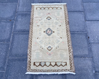 May include: A beige runner rug with a brown and white geometric pattern. The rug has a fringed border.