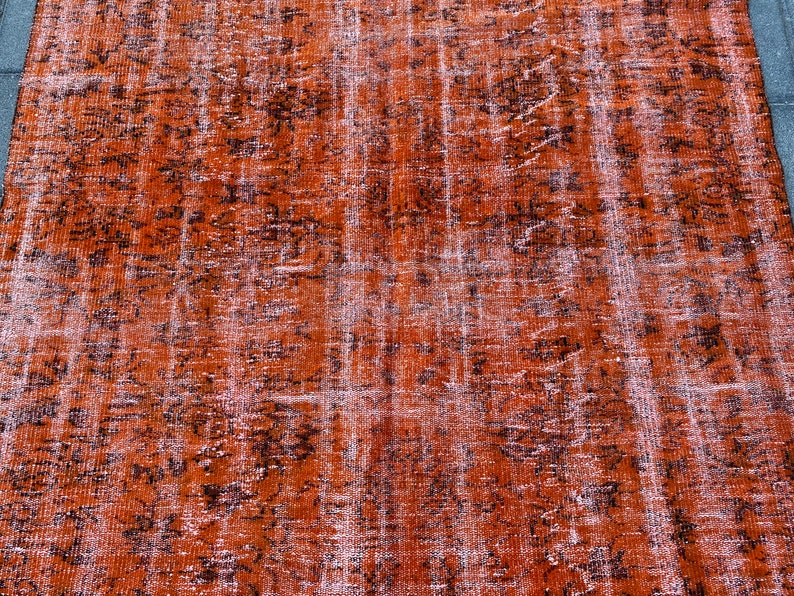 May include: A vintage rug with a distressed, faded look. The rug has a brown and white color scheme with a subtle pattern.