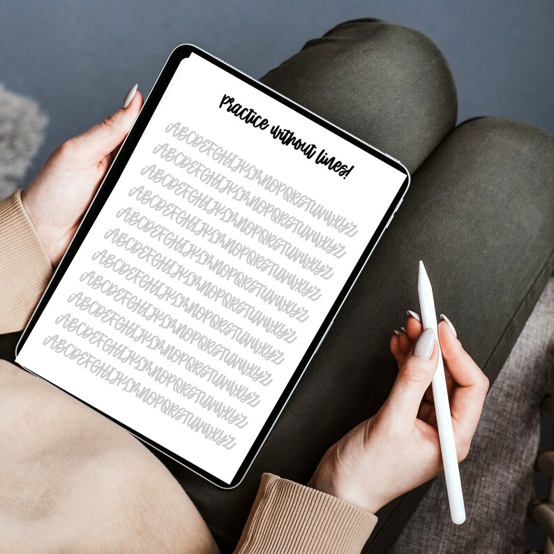 Puede incluir: Una tableta digital blanca con el texto "Practice without lines!" en la parte superior de la pantalla. La pantalla muestra varias l&iacute;neas del alfabeto en una fuente manuscrita.