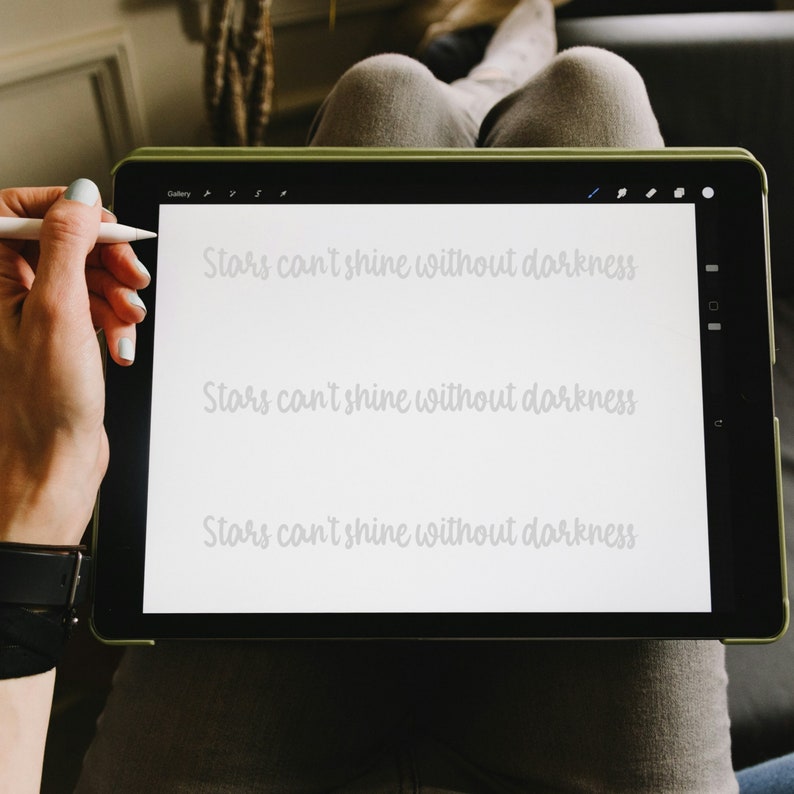 May include: A white digital tablet with a black frame and a green border. The screen displays the text "Stars can't shine without darkness" three times.