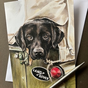 Grußkarte schwarzer Labrador Retriever. - Sind wir schon da? Blankokarte mit schwarzem Labrador auf dem Rücken eines Landrover