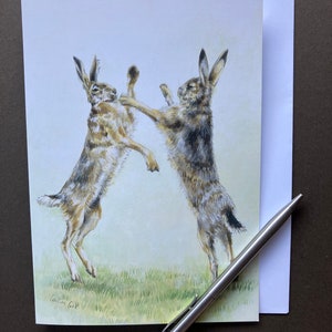 Cartão de arte de lebre marrom "Spring Madness" Cartão de felicitações em branco com lebres