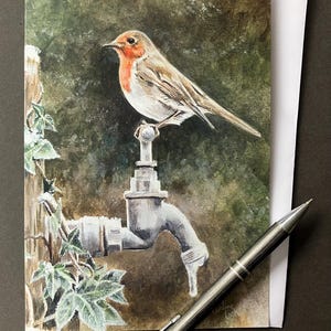 Carte d'art Robin. Carte de Noël ou d'anniversaire vierge avec un Robin sur un robinet givré