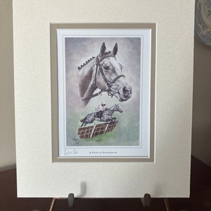 Pode incluir: Uma impressão emoldurada de um cavalo, intitulada "A Study of Lossiemouth". O cavalo é cinza com uma rédea preta e é retratado em uma cena de corrida. A impressão é assinada pela artista, Caroline Cook.