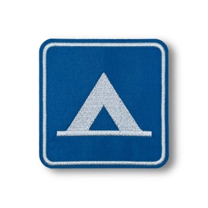 May include: A blue square patch with a white embroidered tent symbol.
