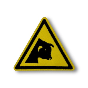 Peut inclure: Un panneau de signalisation triangulaire jaune avec une silhouette noire de tête de taureau à l'intérieur. Le panneau a une bordure noire.